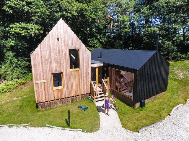 A house with wooden exterior and garden at Lodge 19 in Corfe Castle