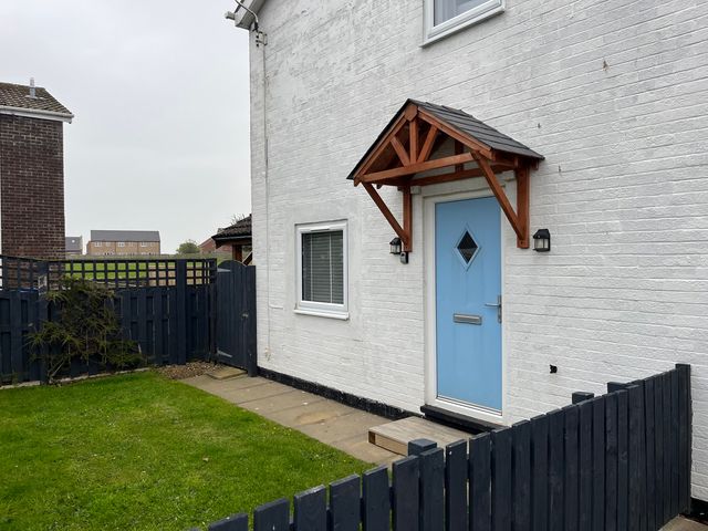 An outdoor area with a blue door and fence at 22 Longstone Park Beadnell