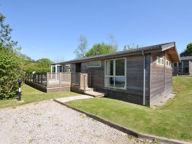 A wooden cabin with a deck and grass area at 7 Valley View Lanreath