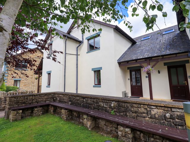 A house with a bench and flower pot in front at Mallard Cottage in Penrith