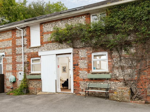 An exterior view of a building with a door and bench at The Stable in Blandford Forum