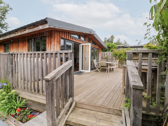 An outdoor area with decking and wooden furniture at Gloccamaura in Bovey Tracey