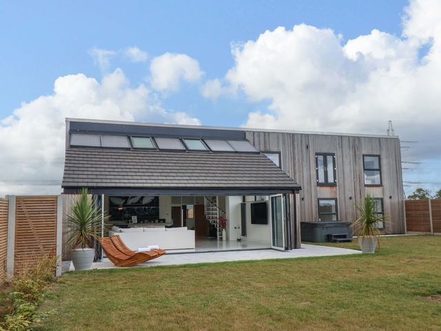 A house with a deck chair and plants in outdoor space at Mill Cottage in Walkington