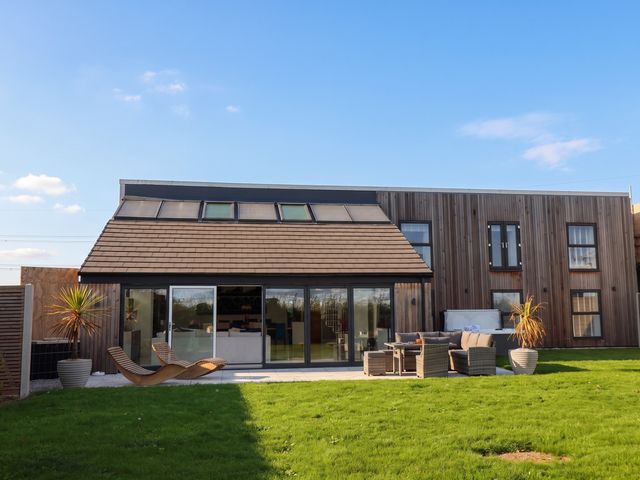 A house with large windows and patio furniture at Meadow View Beverley near Walkington