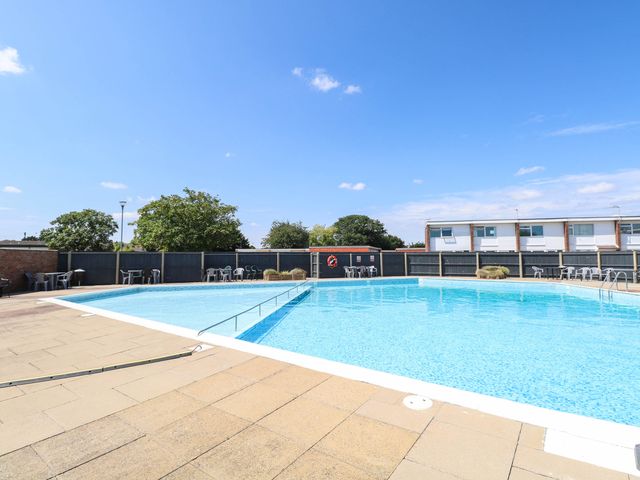 An outdoor swimming pool with deck chairs at 158 Beach Road Chalet Park
