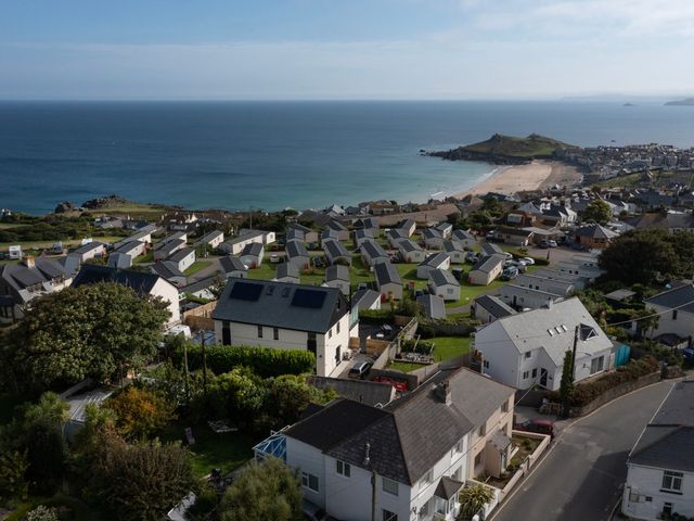 A coastal village with houses and caravans near a beach at Lanyon in St Ives