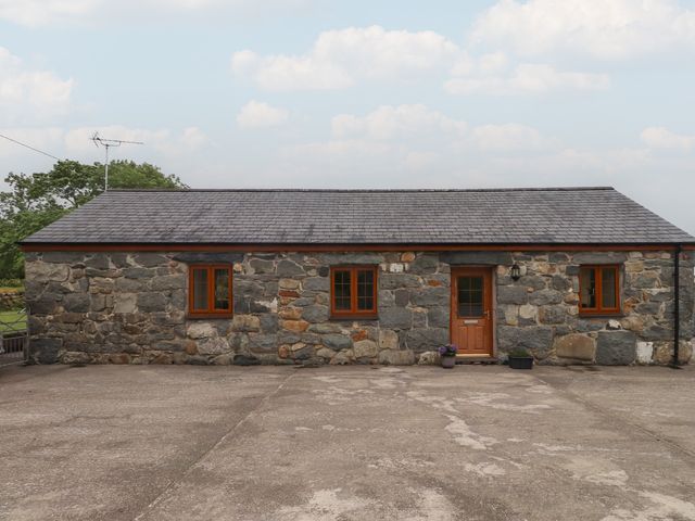 A stone cottage with windows and a door at Bryn Caled in Llanarmon near Y Ffor