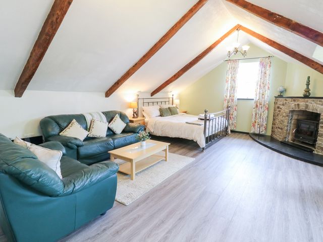 A bedroom with a sofa and bed at Loft apartment in Llandysul