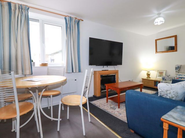 A living room with a dining table and chairs at Seaside Apartment in Looe