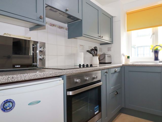 A kitchen with a microwave and oven at Seaside Apartment in Looe