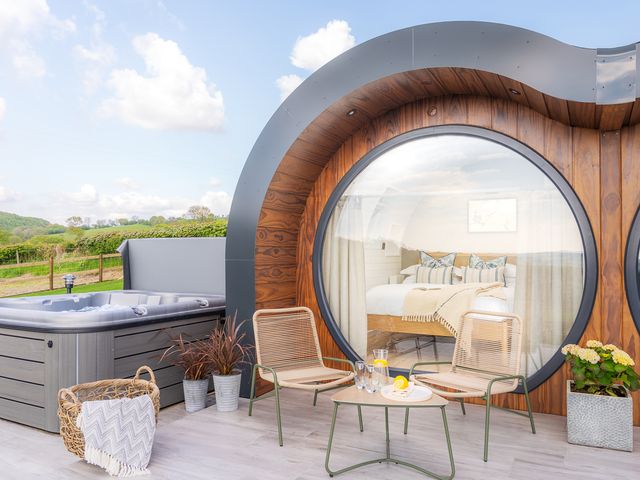 An outdoor area with a hot tub and seating at Ceunant in Llanfihangel-y-Creuddyn near Aberystwyth