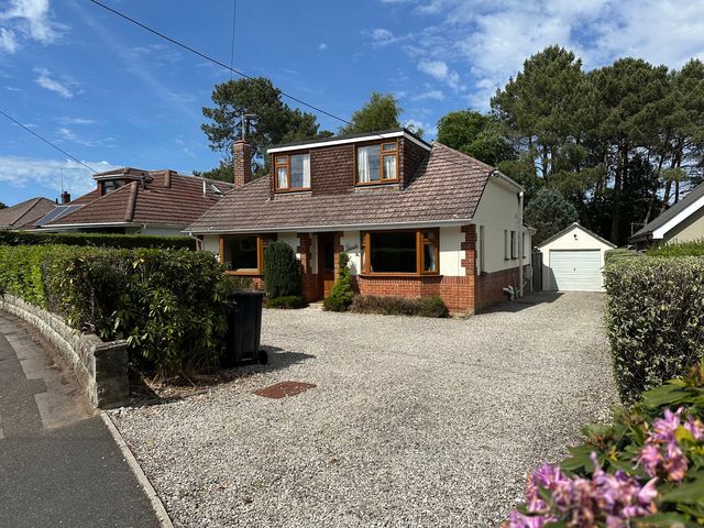A house with a driveway and garage at Pineside, Sandford, Dorset
