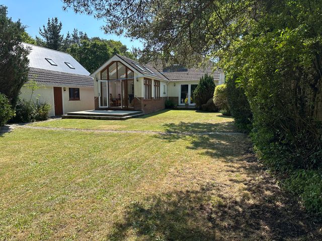 A house with a garden and patio at Pineside Sandford, Dorset