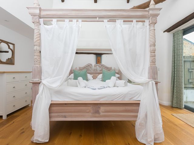 A bedroom with a four-poster bed and chest of drawers at Carines Barns - Wesley Barn, Cubert