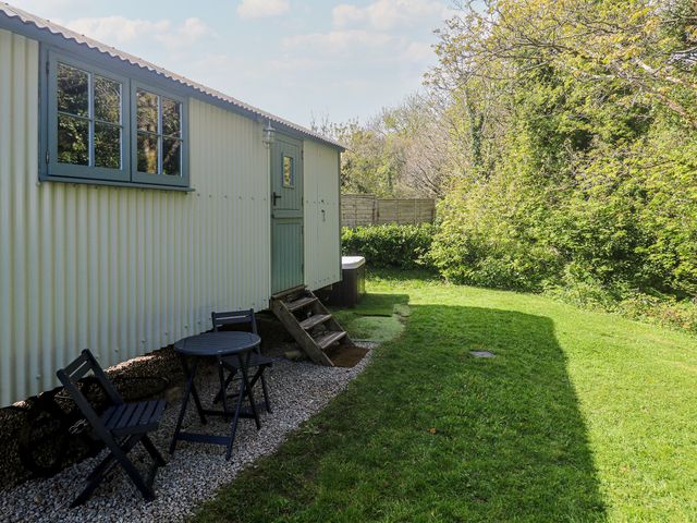 An outdoor area with a shepherd's hut, table and chairs in Angarrack near Hayle