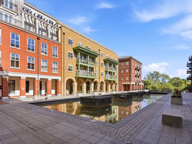 An outdoor area with buildings and a pond at 63 Vista Heights in Solihull