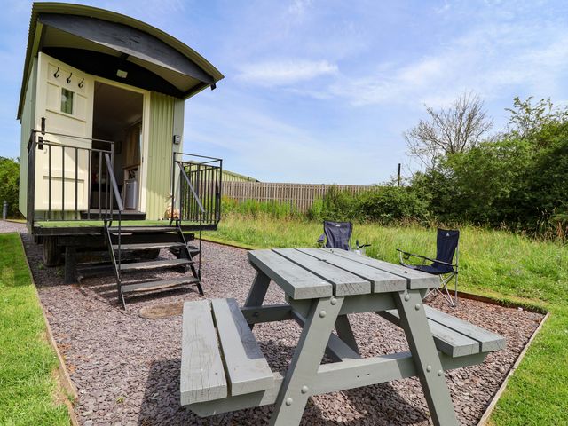 A mobile home with steps and outdoor table at Sid's Nest