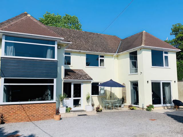 A house with outdoor seating and a parasol at Brooklands in Uplyme
