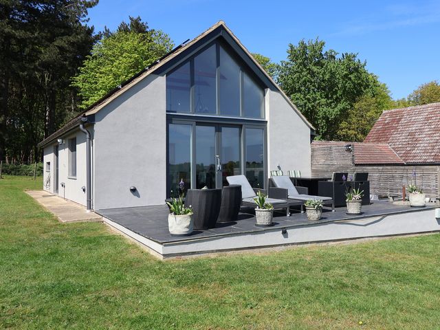 A house with a deck and seating area at Polly's Annexe in Levington