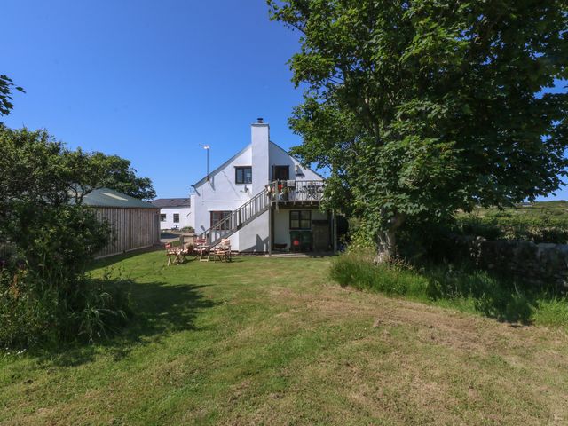 A house with a deck and outdoor seating in the garden at Borth Arian Boat House Holyhead