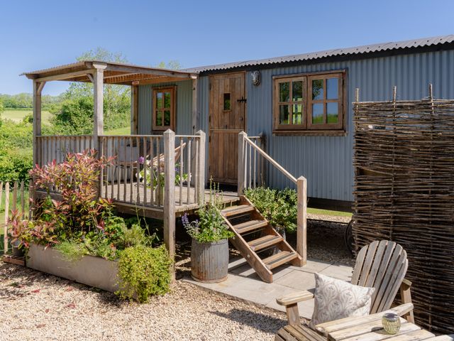 An outdoor hut with steps and planters at Spindleberry Hut in Piddletrenthide