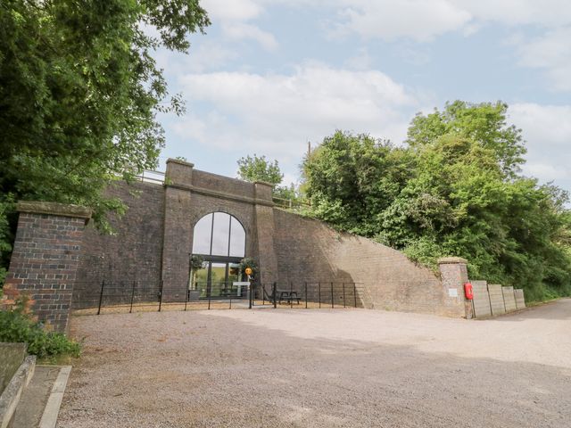 A building with a large window and pathway at The Tunnel at Bridge Lake Farm and Fishery Chacombe