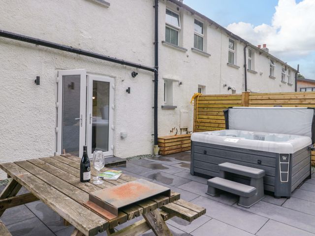 An outdoor space with a hot tub and picnic table at Riverside Cottage No 5 in Keswick