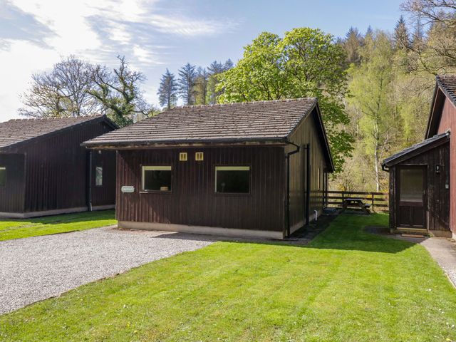 A cabin with a pathway and grass area at Chestnut Timber Lodge in Keswick