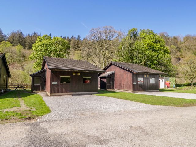 Two cabins with a gravel path and trees at Dogwood Timber Lodge in Keswick