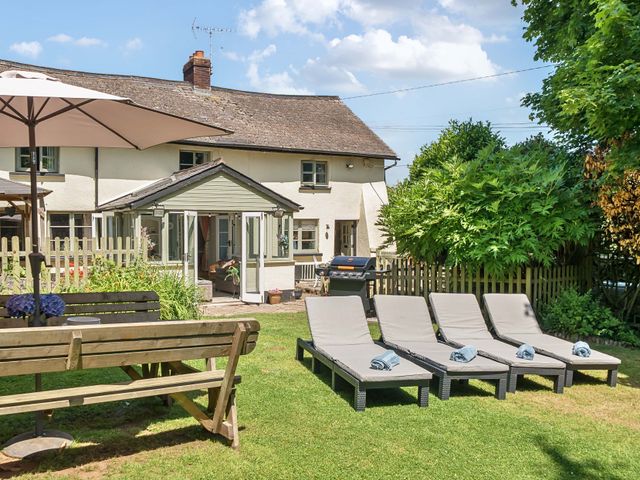 An outdoor space with deck chairs and a patio at 2 Pigsfoot Cottages Ash Thomas near Halberton, Devon