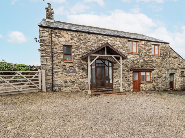 A stone building with a front door and driveway at Horse and Farrier Barn in Newton in Cartmel near Cartmel