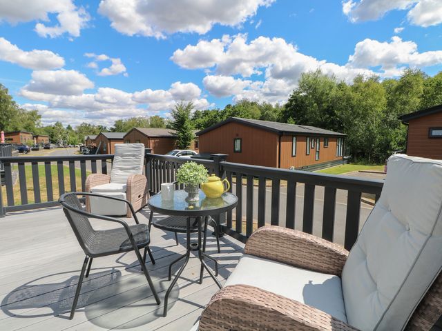 An outdoor terrace with seating and a table at 18 Deer Glade in Landford