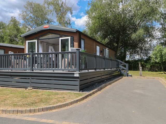 A cabin with a deck and steps at 18 Deer Glade in Landford
