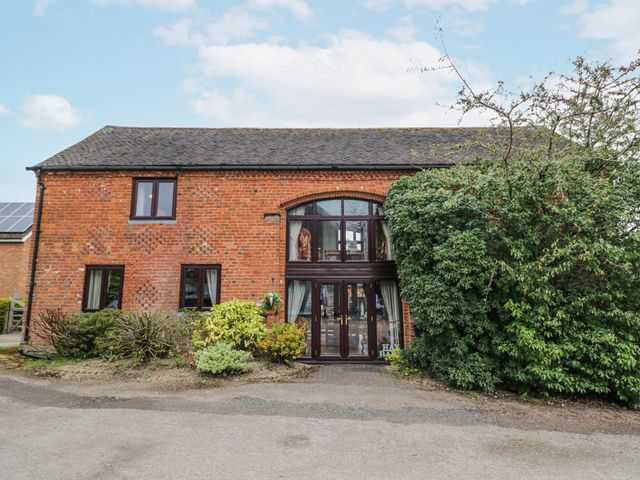 An outdoor view of a brick building with windows and a door at The Haybarn in Lichfield