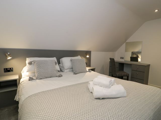 A bedroom with a double bed and folded towels on the bed at Classic Lodge 30 in Dyserth