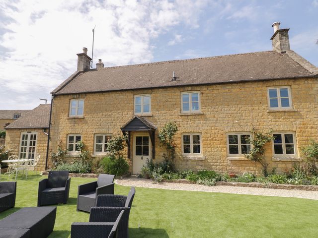 A house with windows and grass at Robins Nest in Bourton-On-The-Water