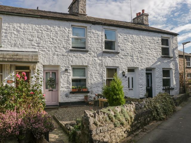 A row of white stone cottages with numbered doors and small front gardens along a street at Gosling Cottage in Kendal