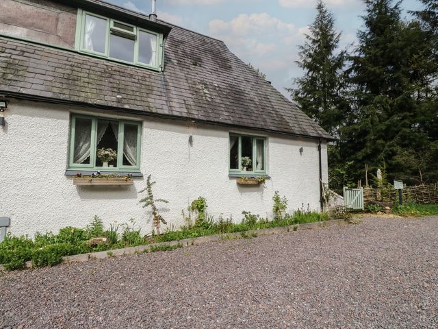 A house with windows and plants in front at The Cottage In The Woods, Connel, Argyll & Bute
