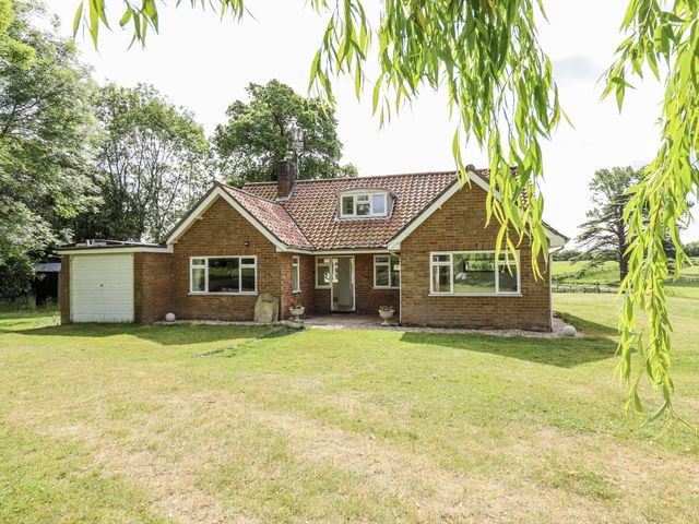 A house with a garage and lawn at Lake View Cottage in Well near Alford