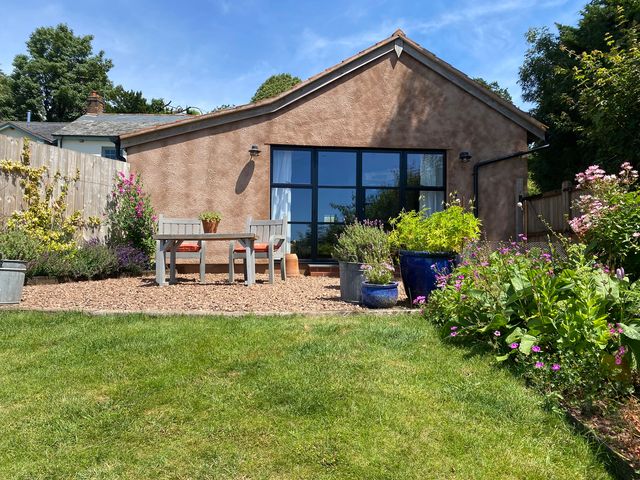 A house with a garden and seating area at Church Farm Dairy Cadbury near Thorverton