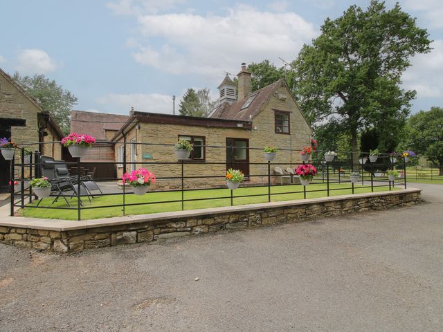 An exterior view of a house with planters at Stables Cottage in Shobdon