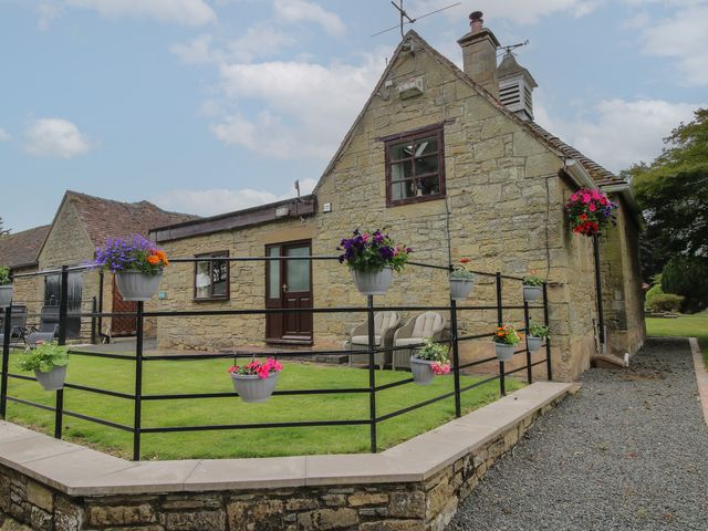 An outdoor area with a fence and planters at Stables Cottage in Shobdon