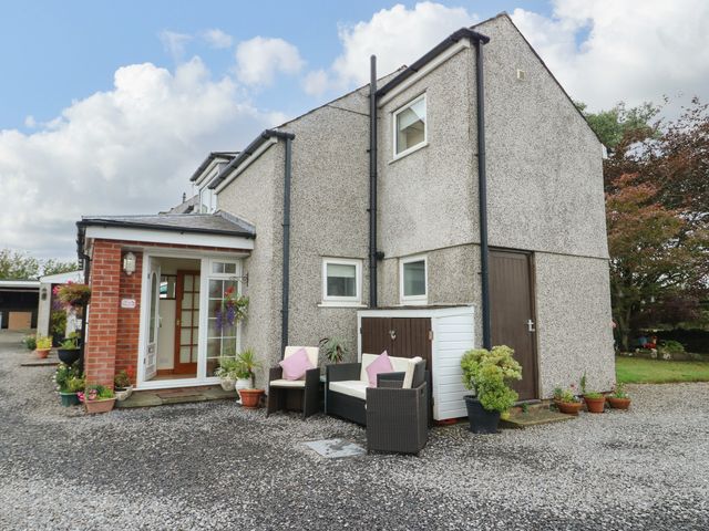 An outdoor area with a house and seating at The Cottage at Ty Newydd Brynsiencyn