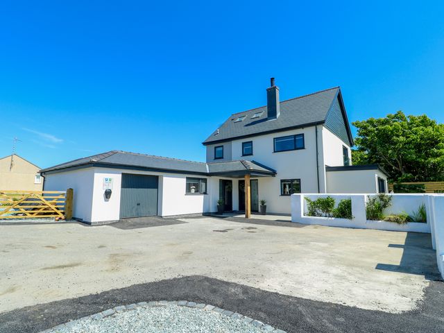 A house with a garage and driveway at Iscoed in Rhosneigr