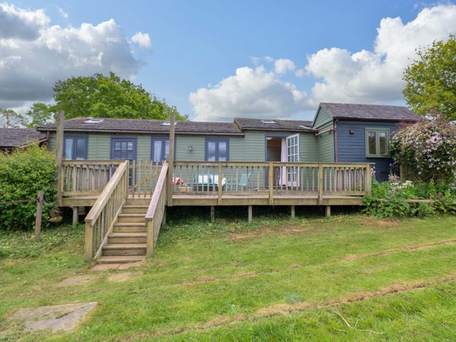 An outdoor area with a wooden deck and steps at Hollyhock in King's Lynn