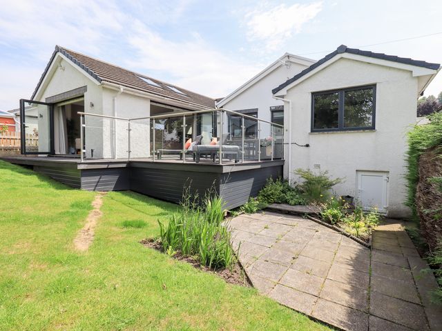 An outdoor area with a deck and garden at Yonder Lea in Bowness-On-Windermere