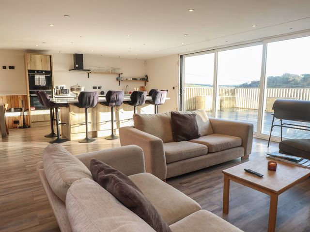 A living room with a sofa and kitchen area at The Hideaway in 