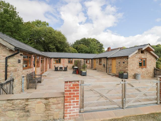 A house with a patio and outdoor furniture at Keepers Barn Bromyard