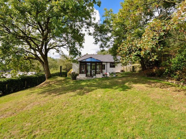 A house with a garden and trees at Barley Cottage in Hartland