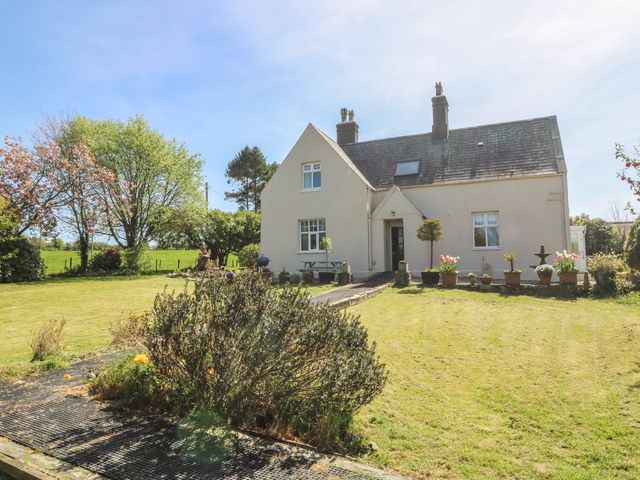 A house with a garden and flower pots at Mallards Rest in Llandwrog near Bontnewydd, Gwynedd